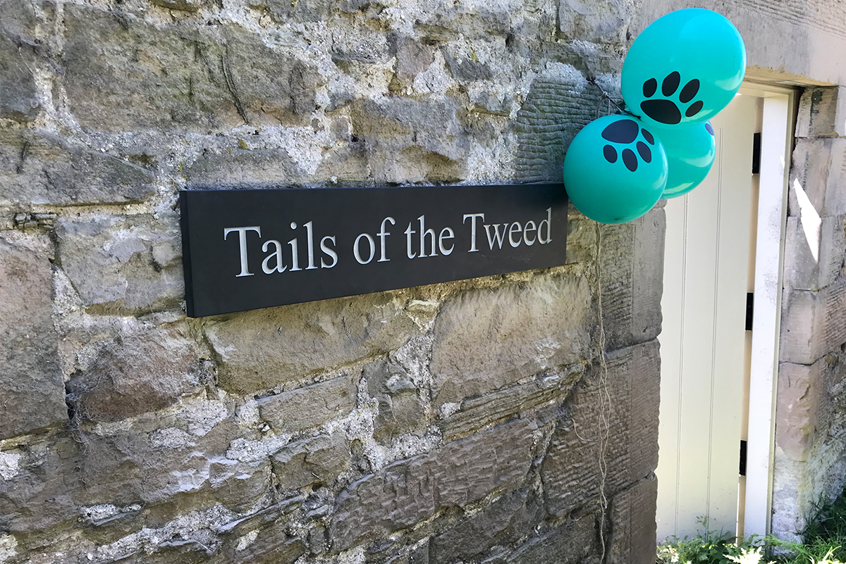 Tails_of_the_tweed_dog_park_sign_with_paw_print_ballons